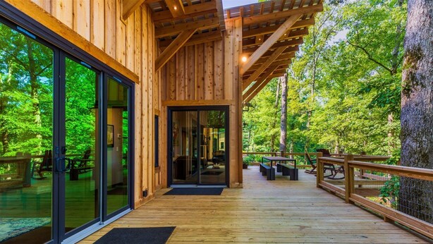 A wooden deck with glass doors leading to a room, surrounded by a forest. - Sugar Shack - Blue Ridge GA (Blue Ridge)