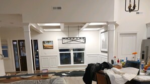 A living room with a couch, a dining table, and a kitchen area.