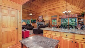 L’intérieur d’un chalet en bois comprend une cuisine, un coin repas et un salon.