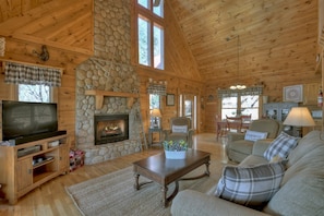 Cozy living room with a fireplace, entertainment unit, and comfortable seating area.