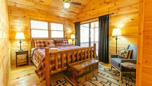 Een gezellig houten blokhut slaapkamer met een houten bed, een bankje, een stoel en een kleine tafel.