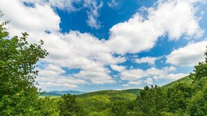 A lush green landscape with a clear sky and mountains in the distance. - Hawk's Hideaway- Blue Ridge GA (Mineral Bluff)