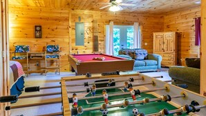 A cozy wooden cabin with a pool table, a foosball table, a sofa, and a cabinet. - Hawk's Hideaway- Blue Ridge GA (Mineral Bluff)