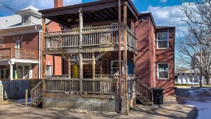 A two-story building with a wooden balcony and a brick facade.