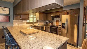 A modern kitchen with granite countertops, stainless steel appliances, and wooden cabinetry. - 01105 - 5 Montserrat Lane (Hot Springs)