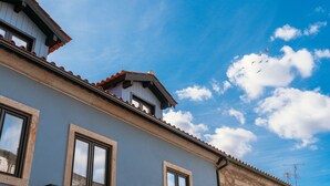 Un bâtiment doté de nombreuses fenêtres et d’un toit recouvert de tuiles.