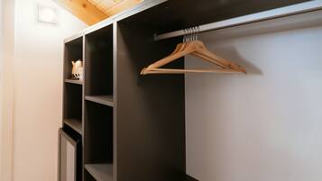 A closet with multiple shelves and a wooden hanger rod.