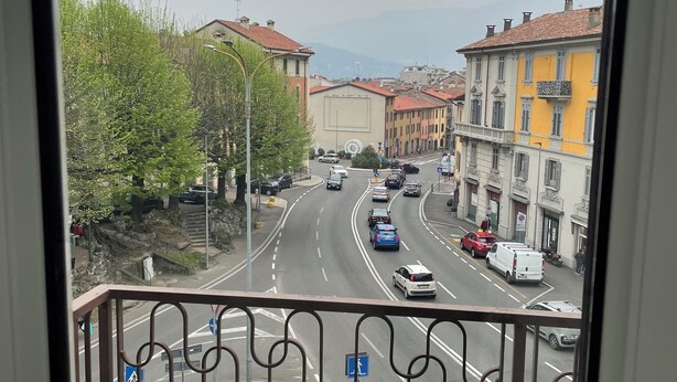 A balcony with a view of a city street, buildings, and a clear sky. - Casa di Silvia Appartamento a soli 20 Minuti a piedi dal suggestivo Lago di Como (Como)