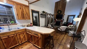 A kitchen with wooden cabinets, a large island, and a stainless steel sink.