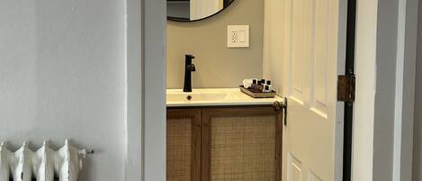 A bathroom with a white sink, a mirror, and a toilet.