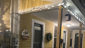 A house with a wooden porch, a welcome sign, and a Christmas wreath.