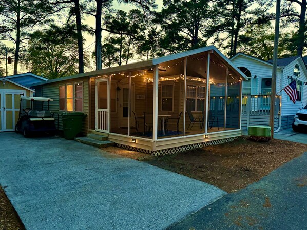 A house with a covered porch, a golf cart, and a flag.