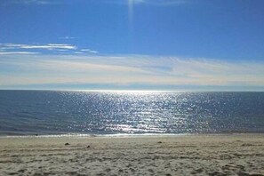A beach with a clear sky and calm sea.