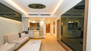 Una sala de estar moderna con un sofá, una mesa de centro y una cocina al fondo.