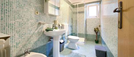 Une salle de bain équipée d’un lavabo, d’un bidet et d’une douche.
