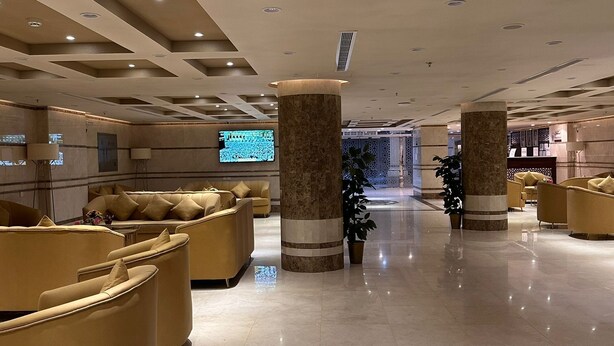 A spacious lobby with modern seating, large pillars, and a television screen. - Radwan Al Diyafah Hotel  (Makkah)