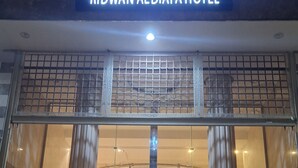 The entrance of Ridwan Aldiafa Hotel with a sign in Arabic and English, large glass doors, and a central column. - Radwan Al Diyafah Hotel  (Makkah)