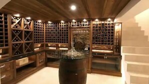 Una bodega con estantes de madera y una barrica central.