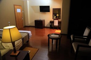 A hotel room with a bed, a desk, a chair, a television, and a small table. - Melka International Hotel (Addis Ababa)
