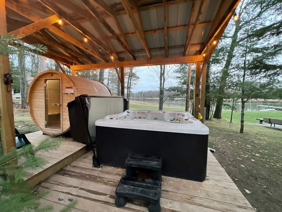 Eine Holzterrasse mit Whirlpool und einer Holzhütte.