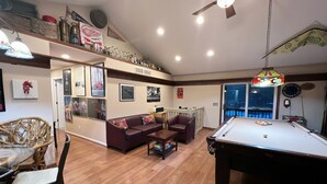 A spacious living room with a pool table, a sofa, and a dining area. - 4-bedroom two level guest house next to Shupac Lake in Grayling (Grayling)