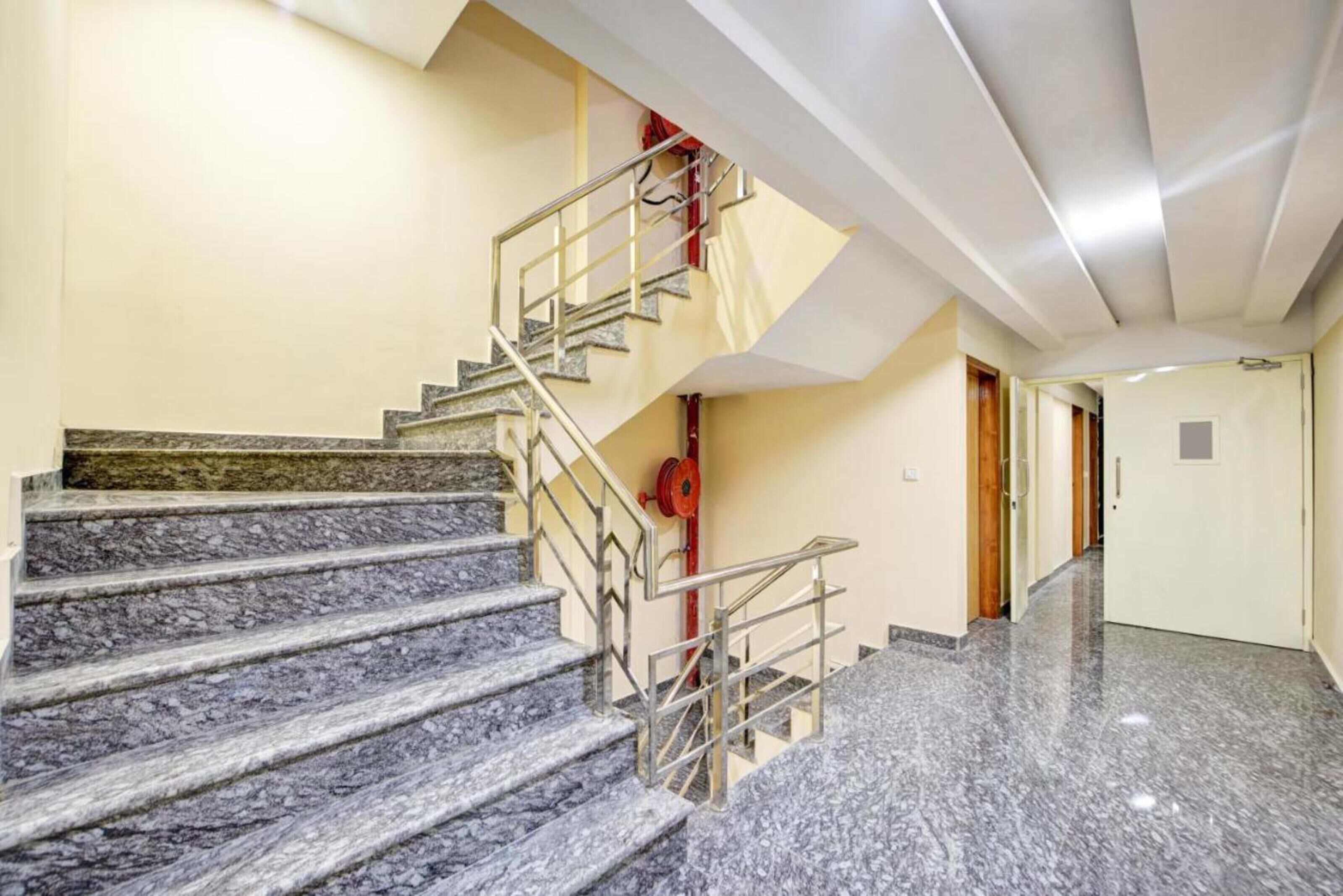 A marble staircase with metal railings leading to a landing.
