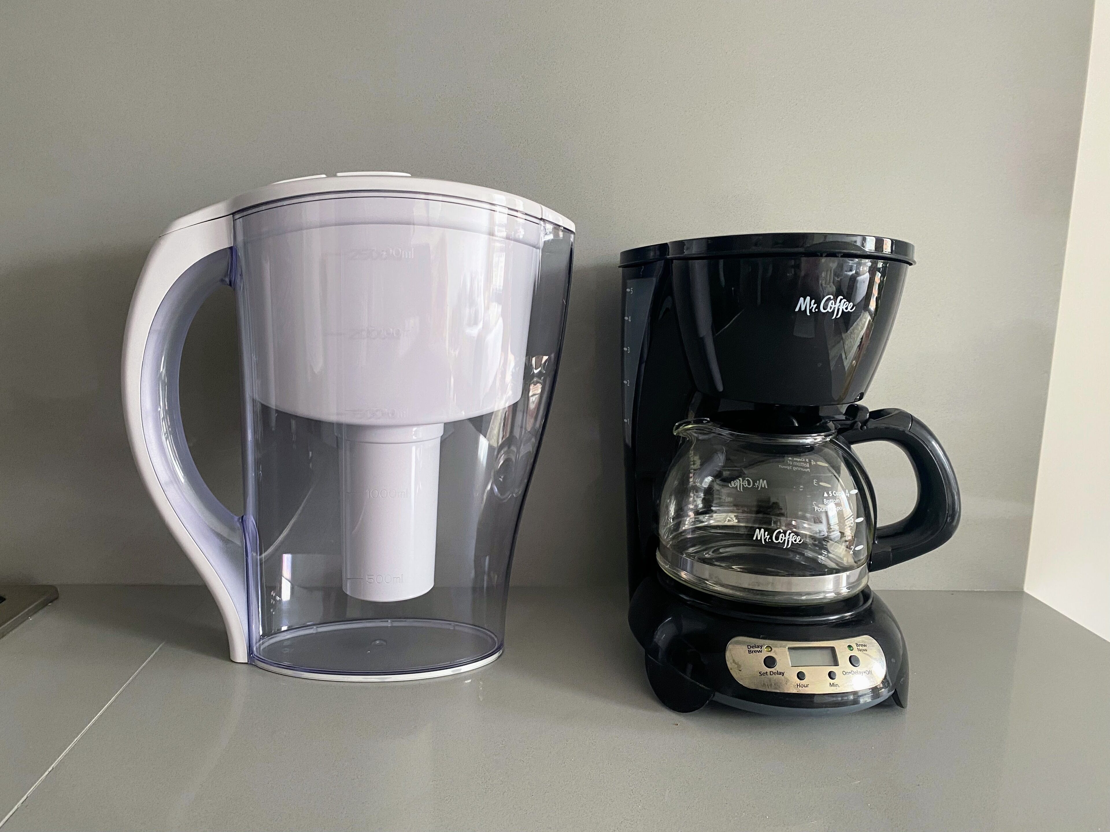 Eine Kaffeemaschine und ein Wasserspender auf einer Arbeitsplatte.