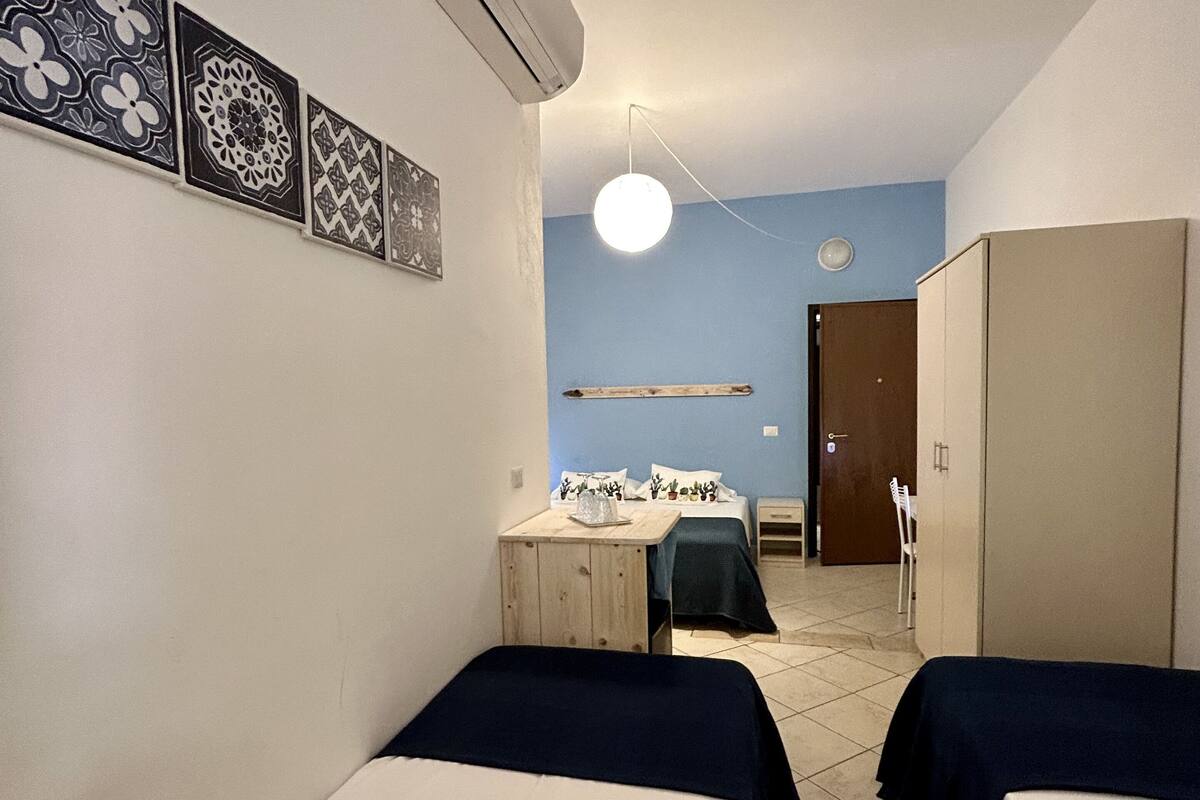 Una habitación con dos camas, un escritorio y un armario.