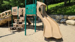 Un parque infantil con un tobogán y estructuras para escalar.