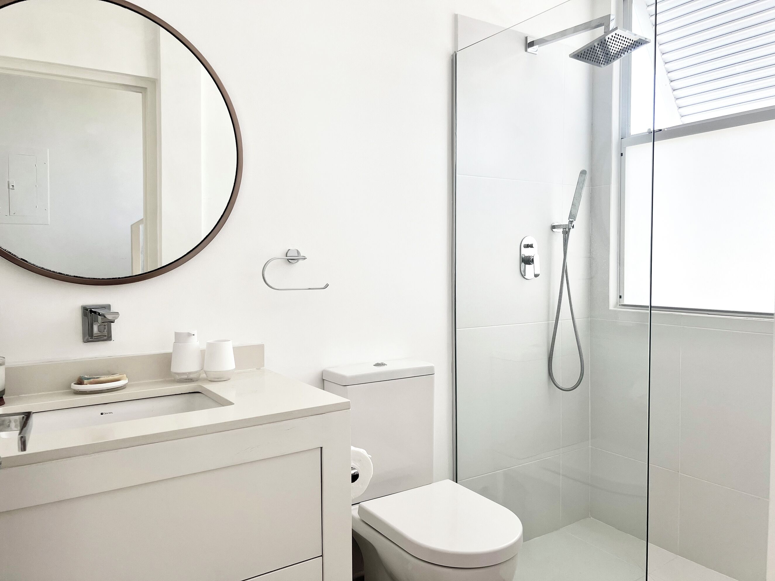 Une salle de bain moderne équipée de toilettes, d’un lavabo et d’une douche.