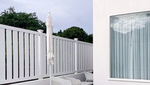 Piscina con cubierta blanca, cerca blanca y ventana con cortinas.