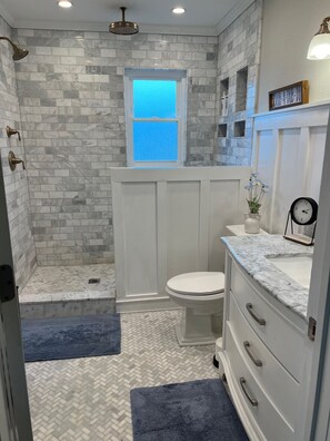 A bathroom with a shower, toilet, and vanity. - Cozy cottage that allows for pets, the experience of outdoors, and the big city! (Monclova)