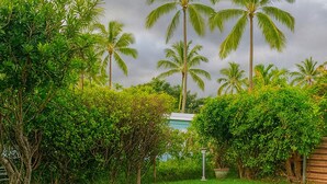 A lush green lawn with palm trees and dense shrubbery. - Mauka Sunrise, Walk to Hau‘ula Beach & Trails, A/C (Hauula)