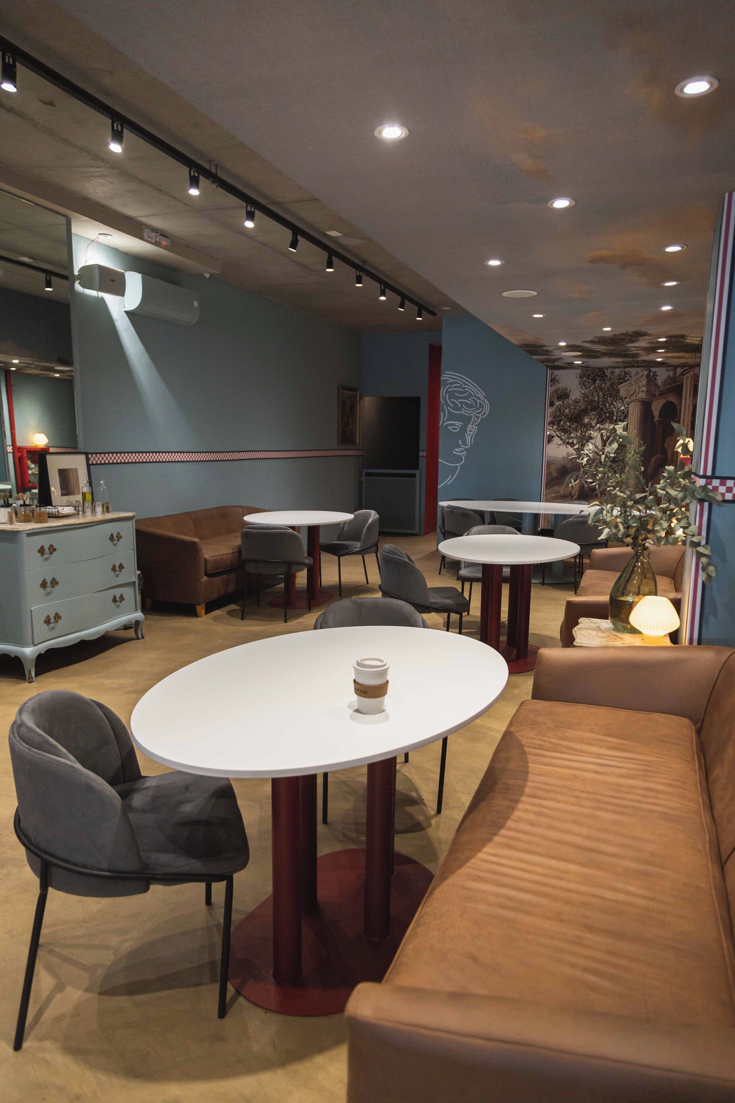 A modern lounge area with round tables, sofas, and chairs.
