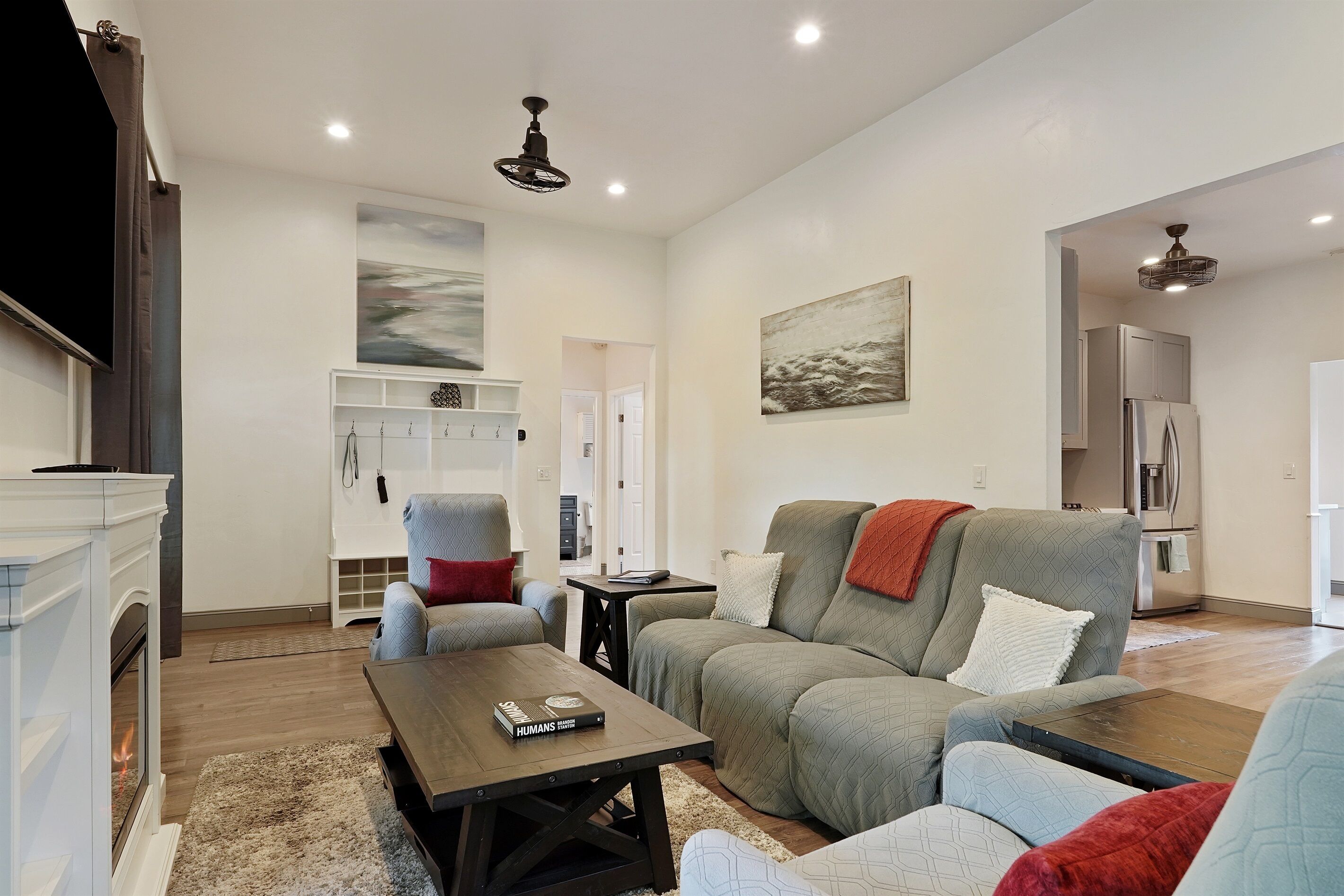 Ein modernes Wohnzimmer mit Kamin, einer Sofagarnitur, einem Couchtisch und einem Gemälde an der Wand.