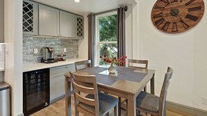 Een moderne keuken met een ingebouwde vaatwasser, een achterwand van steen en een grote houten klok aan de muur.