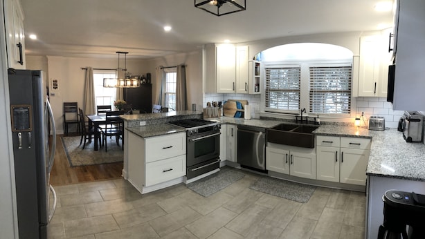 A modern kitchen with granite countertops, stainless steel appliances, and white cabinetry. - Spacious 6BR, 10 bed Derby House. Walk to the track. (Louisville)