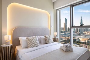 Ein modernes Hotelzimmer mit einem großen Bett, Blick auf die Stadt und einem außergewöhnlichen Design des Kopfteils.