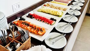 A buffet table with various food items and utensils.