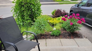 A residential street with houses, a parked car, and a garden with a bench. - Jack and Jill private suite, safe and relaxing 2 bedroom apartment @ RoseGlen  (Niagara-on-the-Lake)