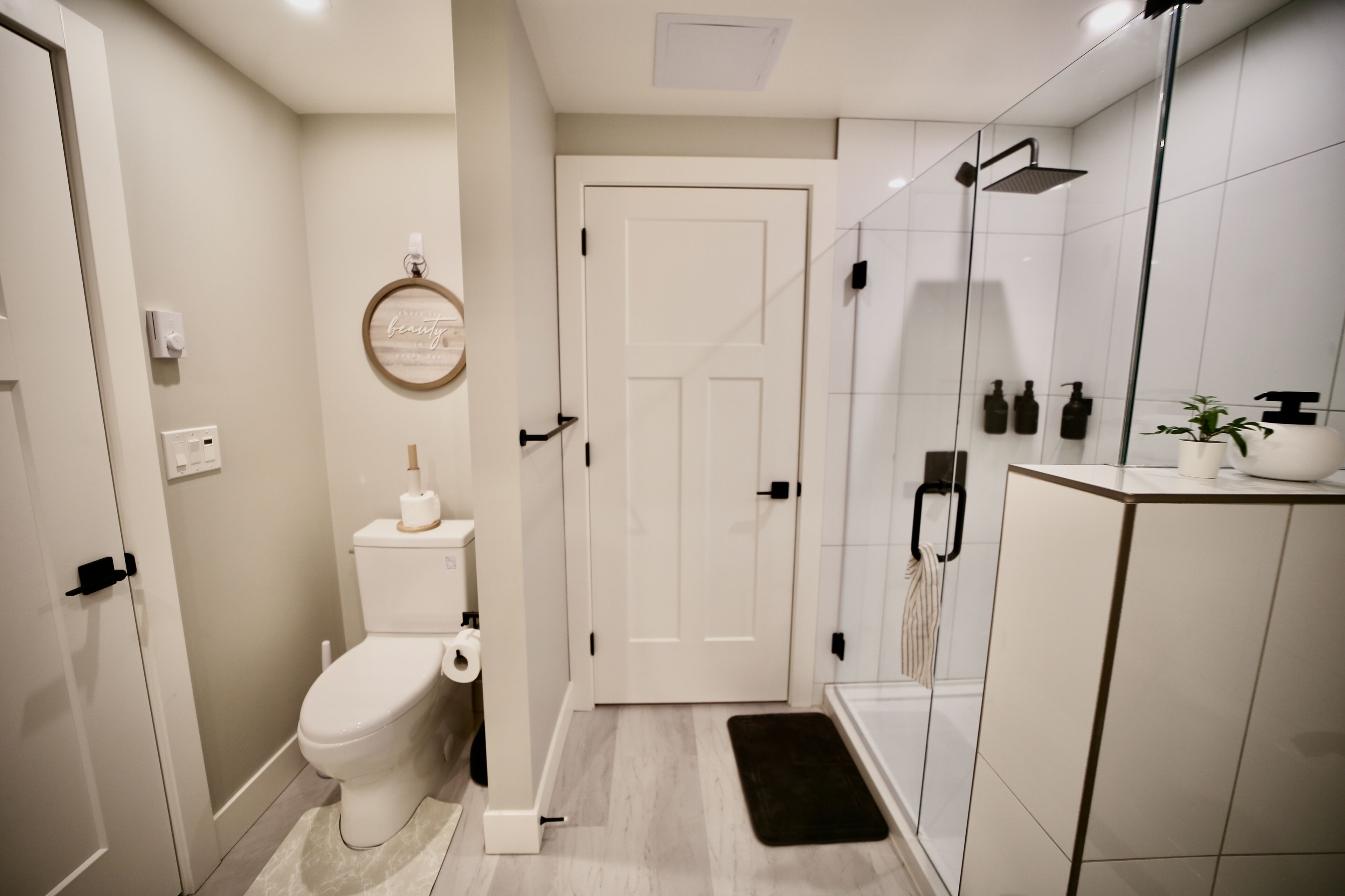 A modern bathroom with a toilet, a shower, and a vanity.