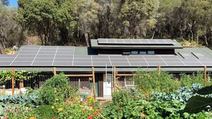Une maison dotée d’un toit végétalisé et de panneaux solaires.