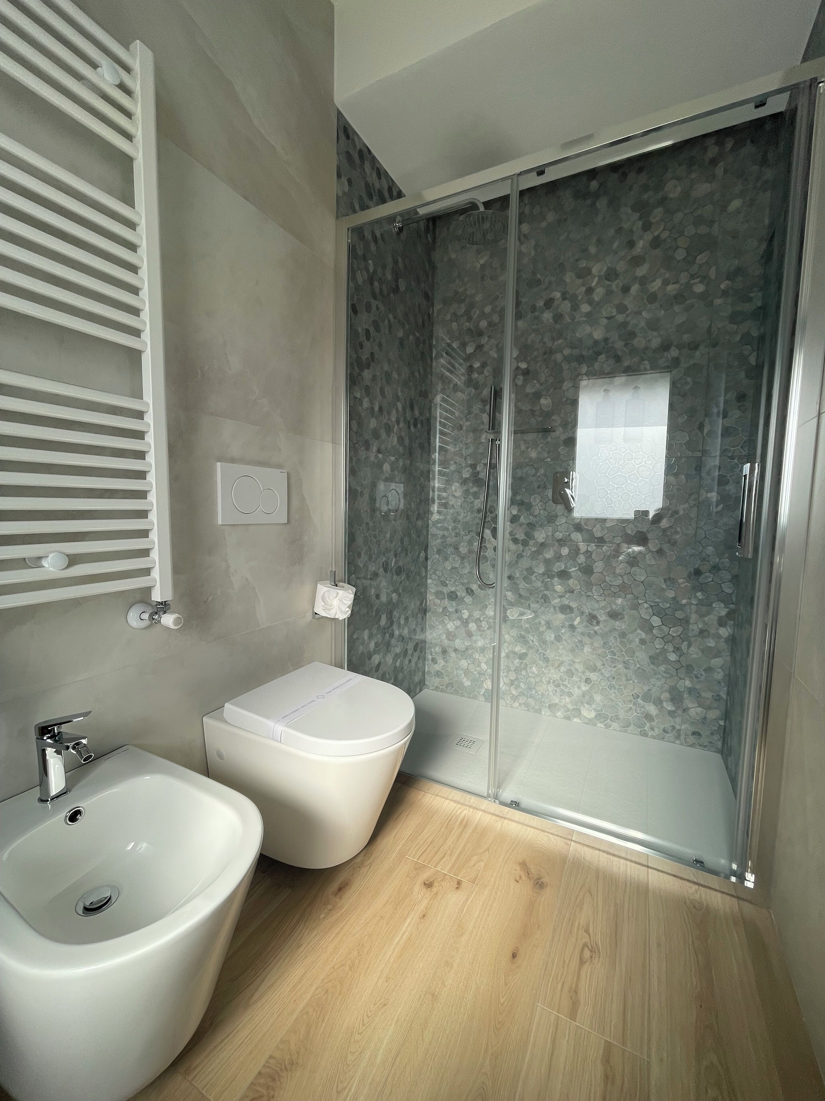 Un baño moderno con ducha, bidé y lavamanos.