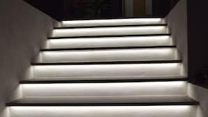Un escalier dont les marches sont illuminées, menant à un espace intérieur.