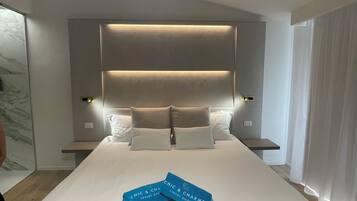 Una habitación de hotel moderna con una cama grande, una mesita de noche y una mesilla.