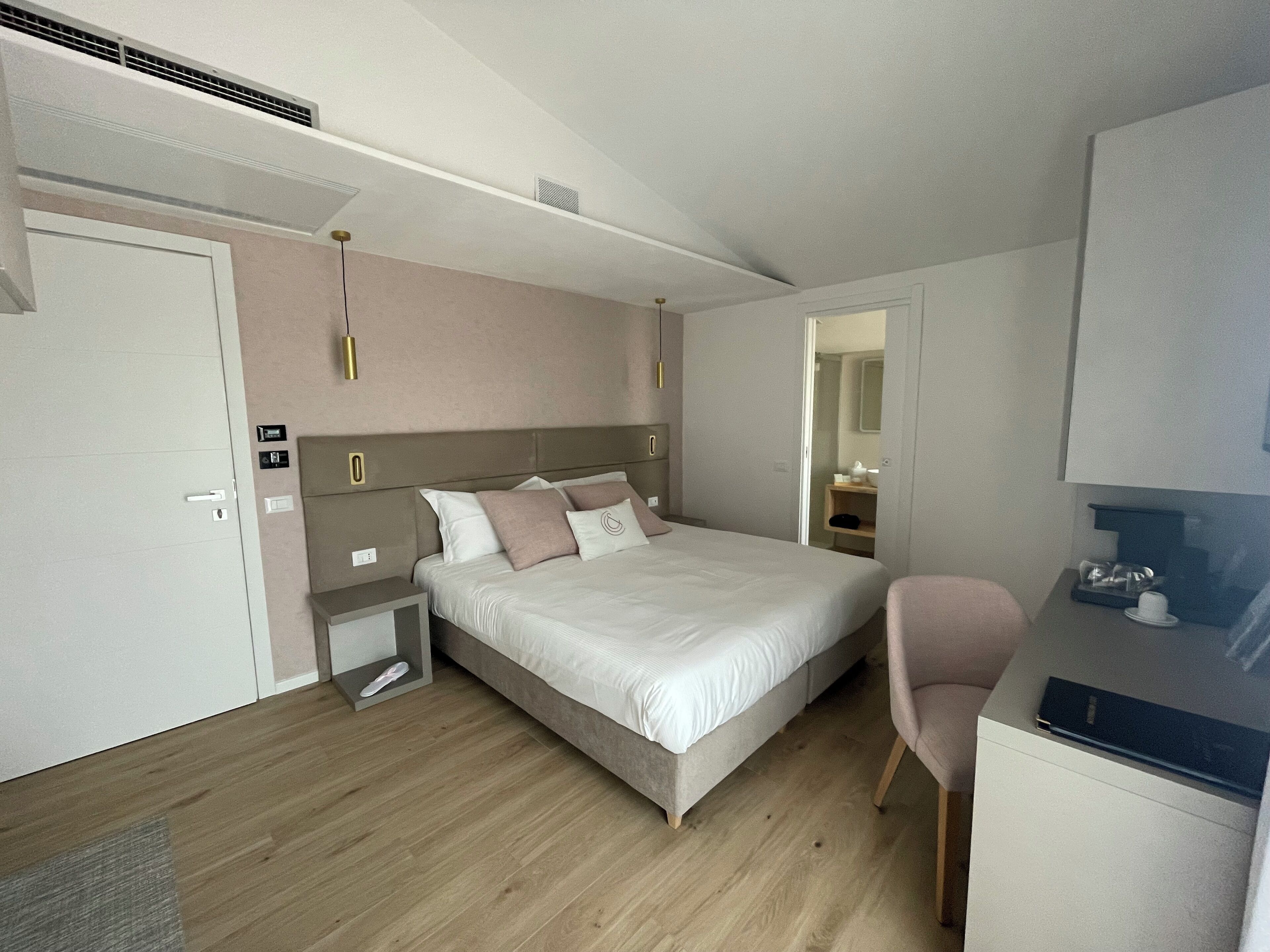 Une chambre à coucher moderne avec un lit, des tables de chevet, une chaise et un bureau.