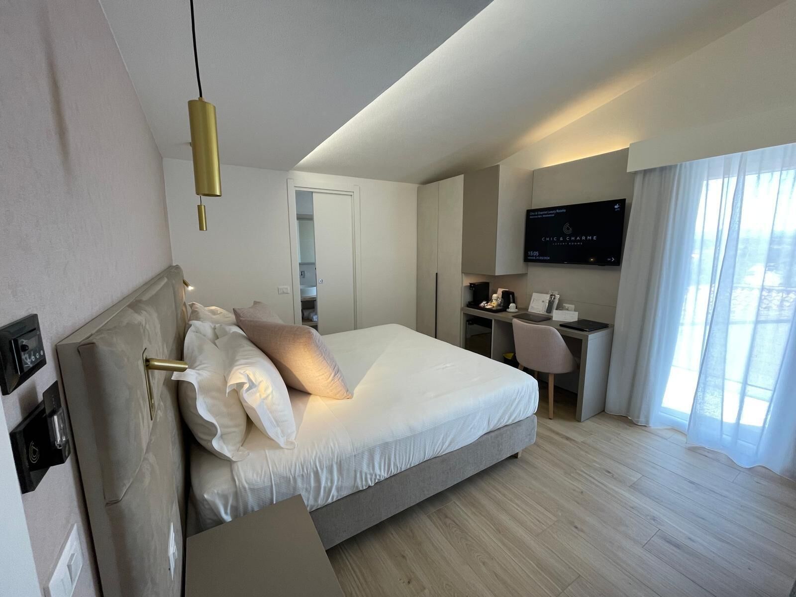Una habitación de hotel moderna con una cama grande, un escritorio y un televisor.