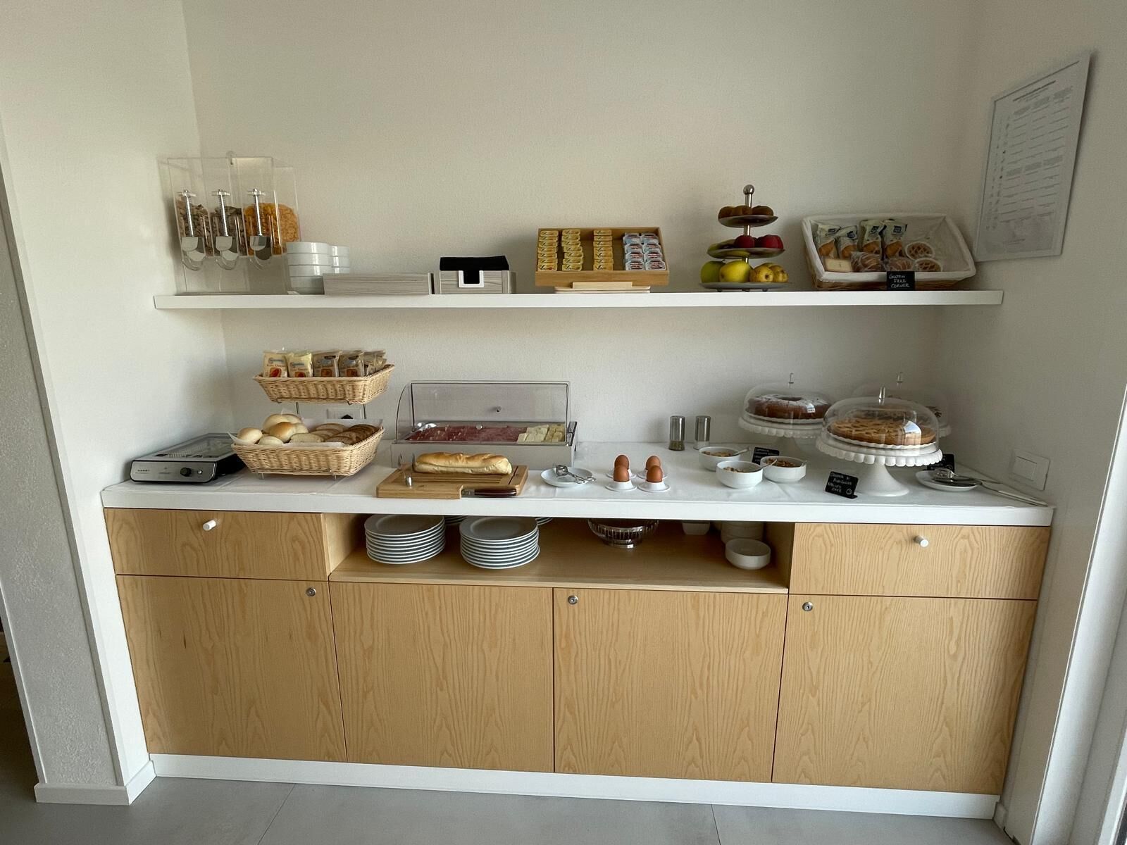 A breakfast buffet setup with various food items and condiments.
