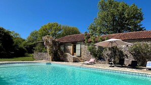 A stone building with a tiled roof, a swimming pool, and lounge chairs. - Maison Nina: un Ancien Corps de Ferme Rénové Avec Piscine, Entre Dordogne et Lot (CAMPAGNAC LES QUERCY)