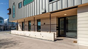 A modern building with a flat roof, large windows, and a concrete walkway. - Rooftop Terrace Near Downtown Fort Worth (Fort Worth)